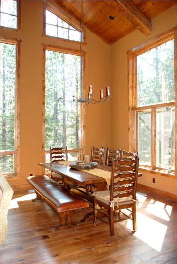 Large dining room table overlooks the surrounding woodlands and the sixth fairway of Sierra Star Golf Course Mammoth Lakes, CA.