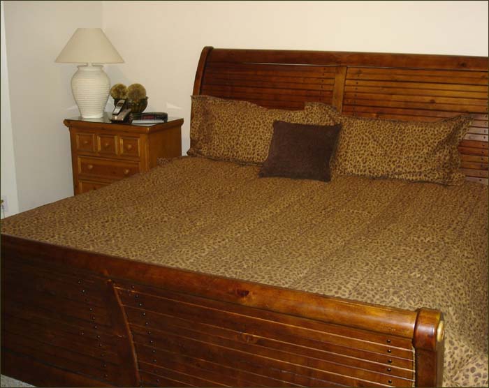 Queen bedroom features plump bedding and shared bathroom!