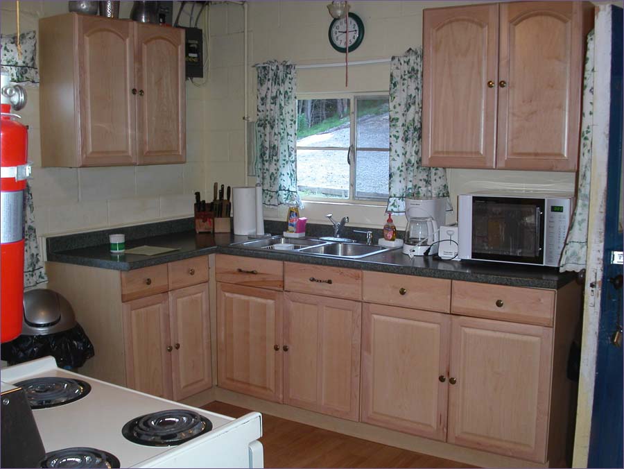 A fully equipped kitchen with stove, microwave, pots, pans and serving ware for a family of 10.