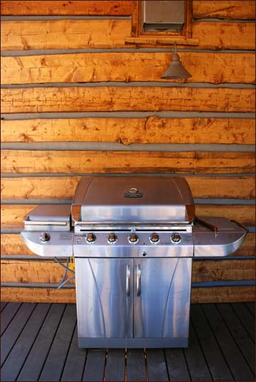 Large free standing gas BBQ grill on the upper level log deck.